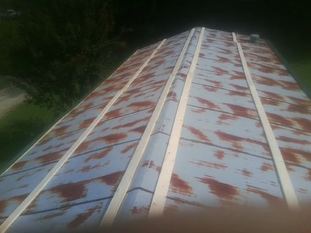 Rusted metal roof panels with new wood purlins before replacement — Storm Damage Roof Repair in De Ruyter by Roofing Brothers